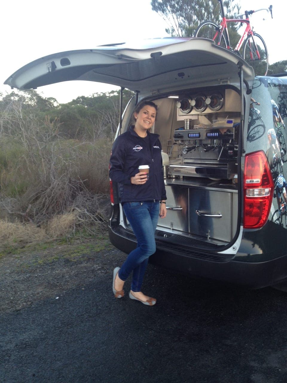 A compact coffee van parked by the beach